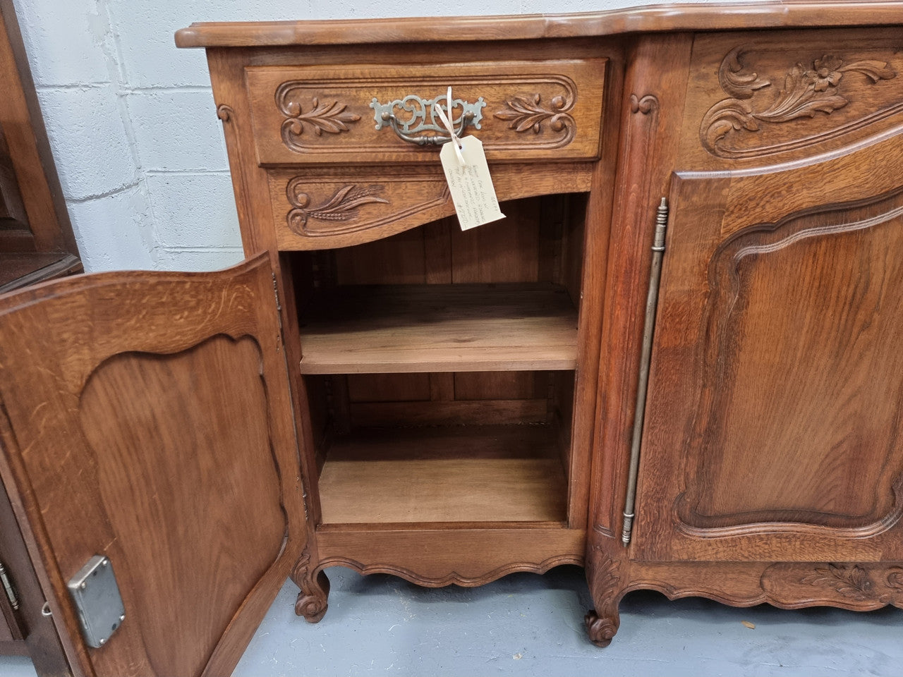Parquetry top French oak Louis XV style sideboard with two draws and four cupboards. In good original detailed condition.