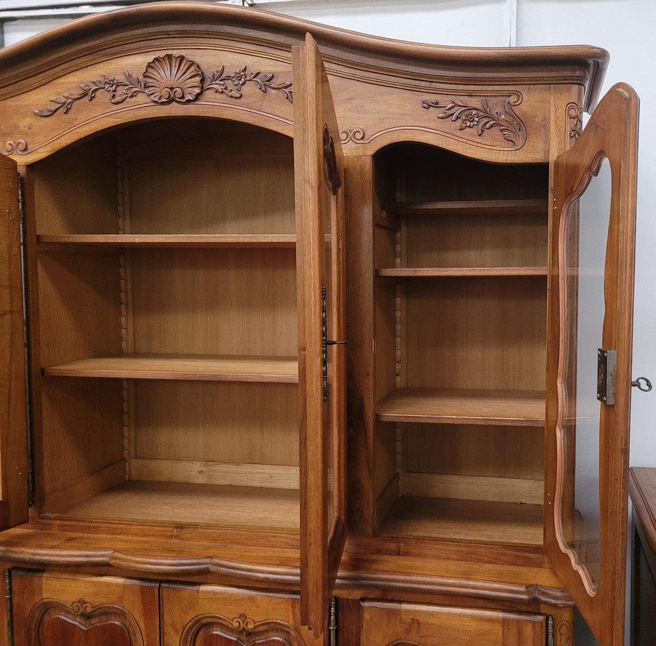Magnificent French Walnut two-body four door display cabinet. Heaps of storage space with four glass doors at the top with shelves and four solid doors below also with shelving. It has been sourced from France and comes with a key for each door and all are lockable. In good original detailed condition.