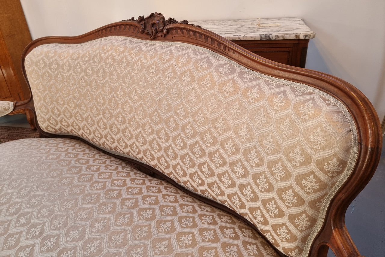 A late 19th Century French Walnut Louis XV style settee with a serpentine front. This settee upholstery is like new and is in very good condition.