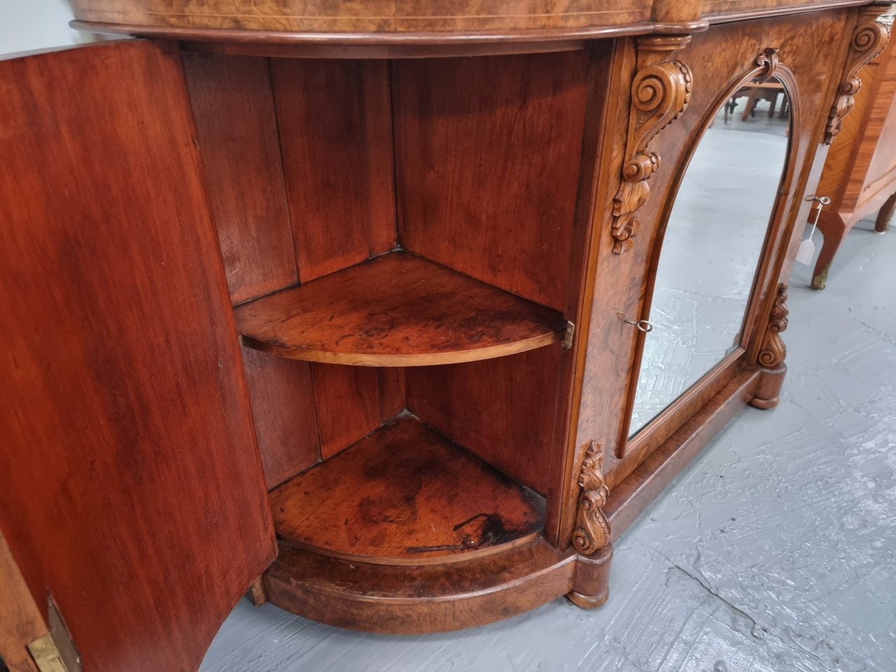 An elegant Antique Victorian Burr wood Walnut marble-top sideboard credenza with a mirrored center door. It has a white shaped marble top, mirror front, nicely carved details and three swing doors along with two keys. It is in good original detailed condition.