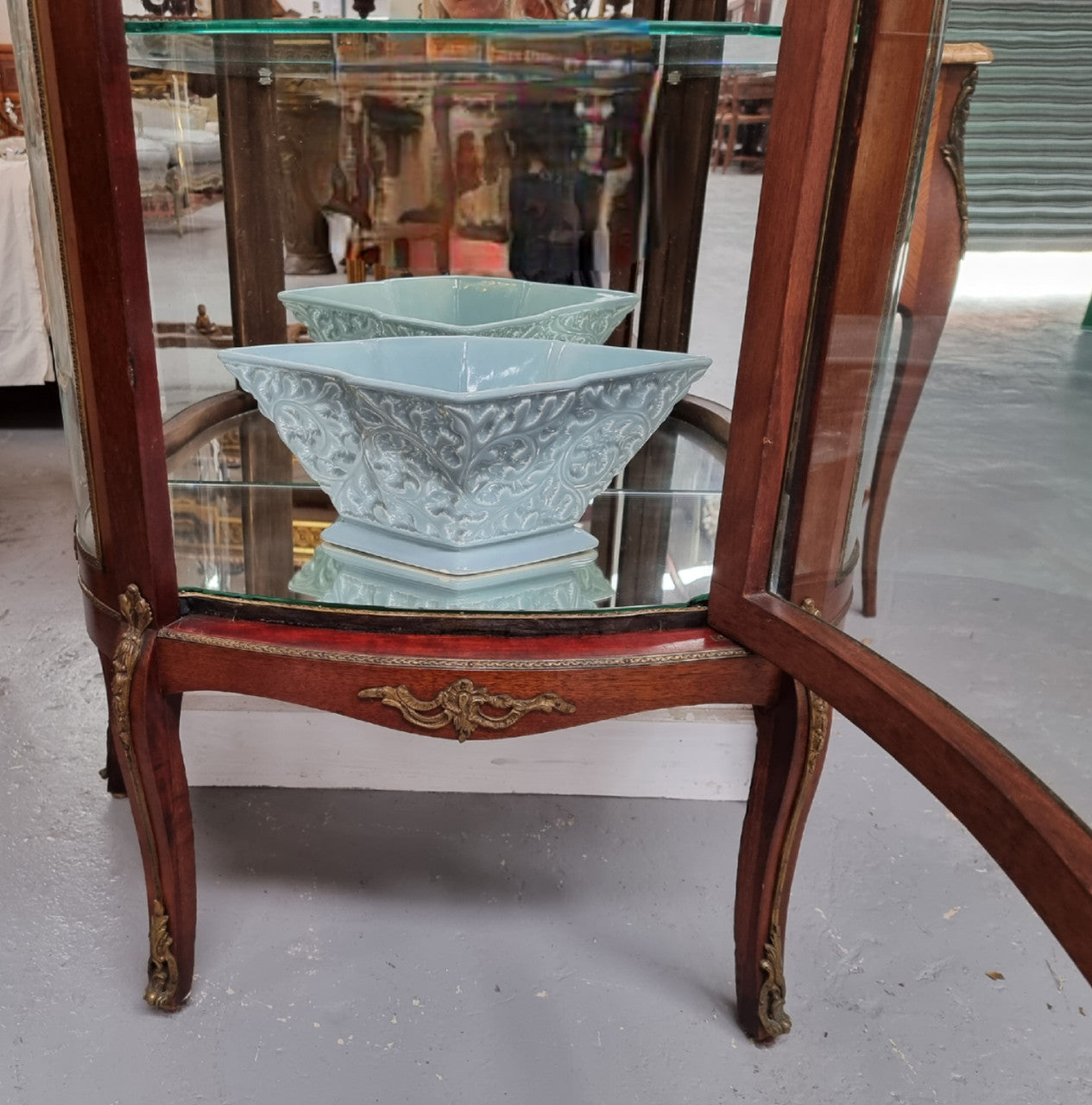 Beautiful French Louis XV style vitrine/ display cabinet with curved glass, gilt mounts, mirrored back and two glass shelves for your displays . It is in good original detailed condition.