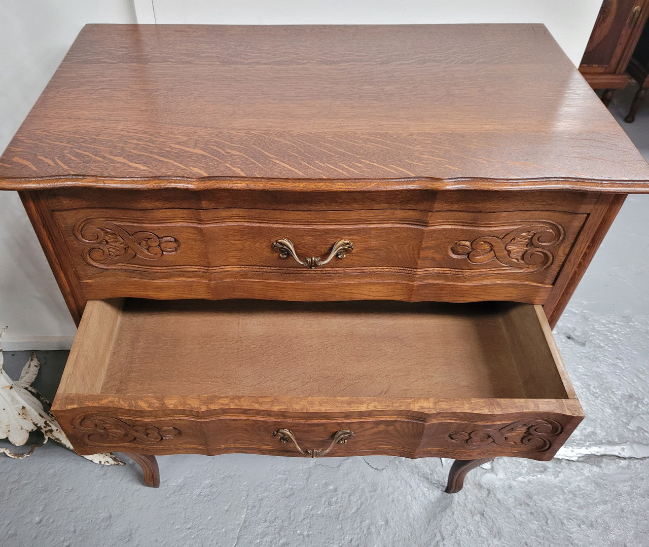 French Oak Louis XV style three drawer commode. It has been sourced from France and has decorative handles and carvings. It is in good original detailed condition.