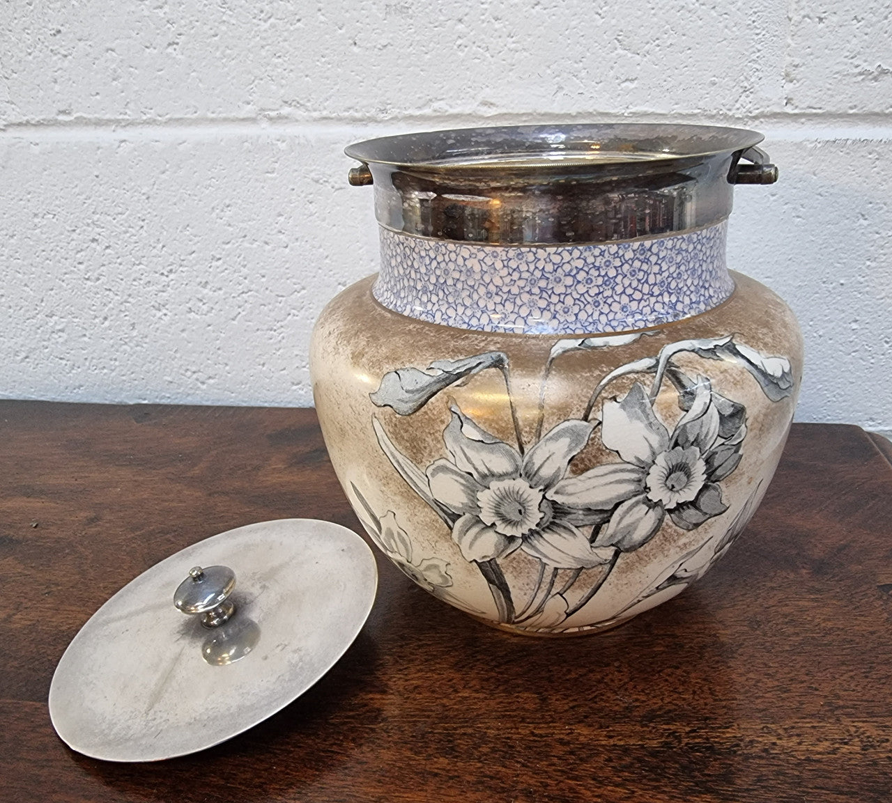 Royal Doulton Biscuit Barrel with silver plated top, handle and lid. Displaying a Daffodil pattern. In original condition please view photo's as they form part of the description.