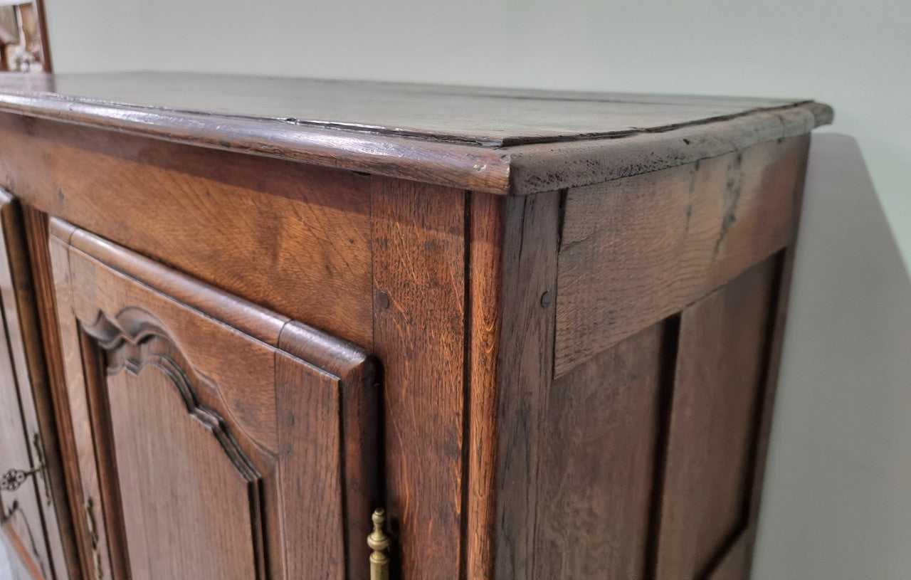 A charming French Oak early 18th Century two door sideboard. Plenty of storage space with two fixed shelves either side. It is in good original detailed condition for its age and comes with a working key and working locks.