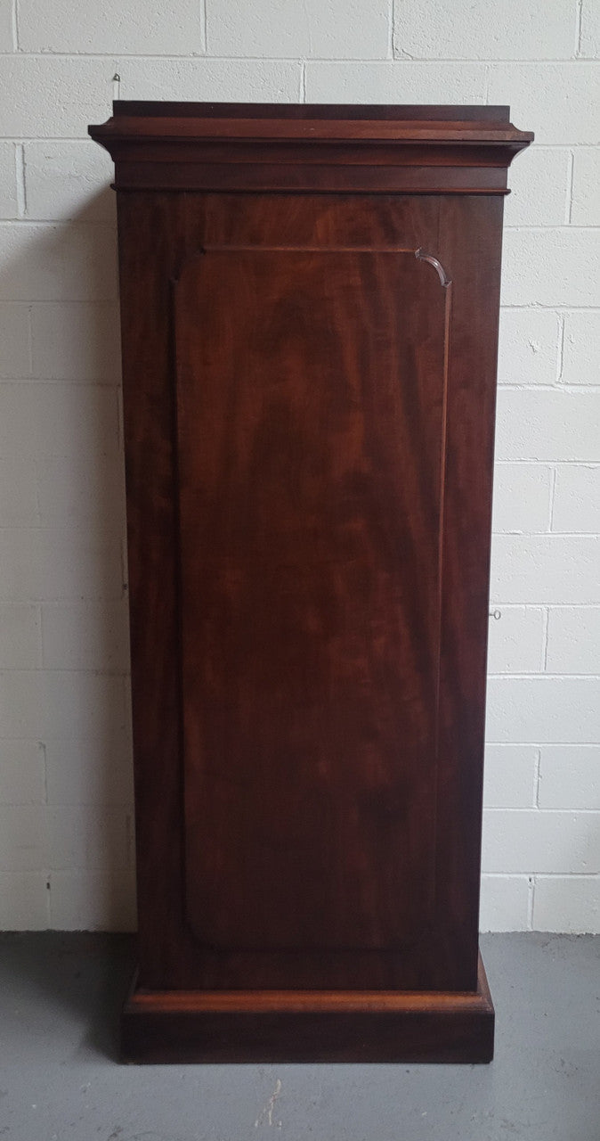 Unusual Victorian Flame Mahogany side wardrobe with side door. It has full hanging and six hooks. The wardrobe opens from a side door which can be locked with its key and has a markers mark stamp on the door. It is in good original condition.