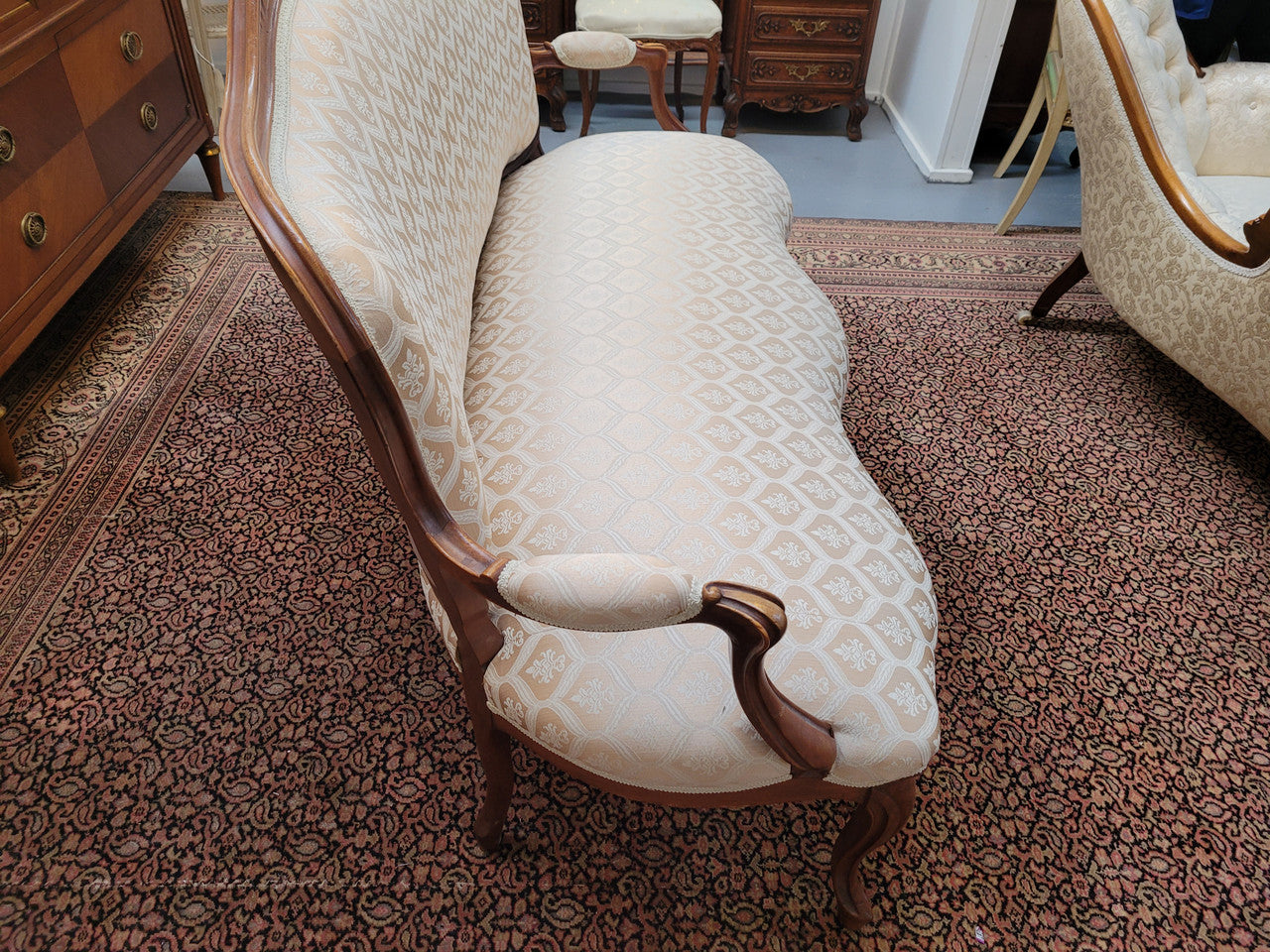 A late 19th Century French Walnut Louis XV style settee with a serpentine front. This settee upholstery is like new and is in very good condition.