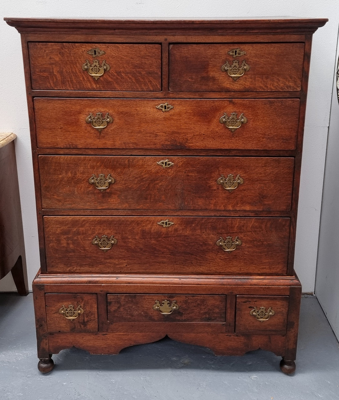 Early 19th Century English Oak chest on stand. It has been sourced in France and has plenty of storage space with eight drawers. In good original detailed condition.
