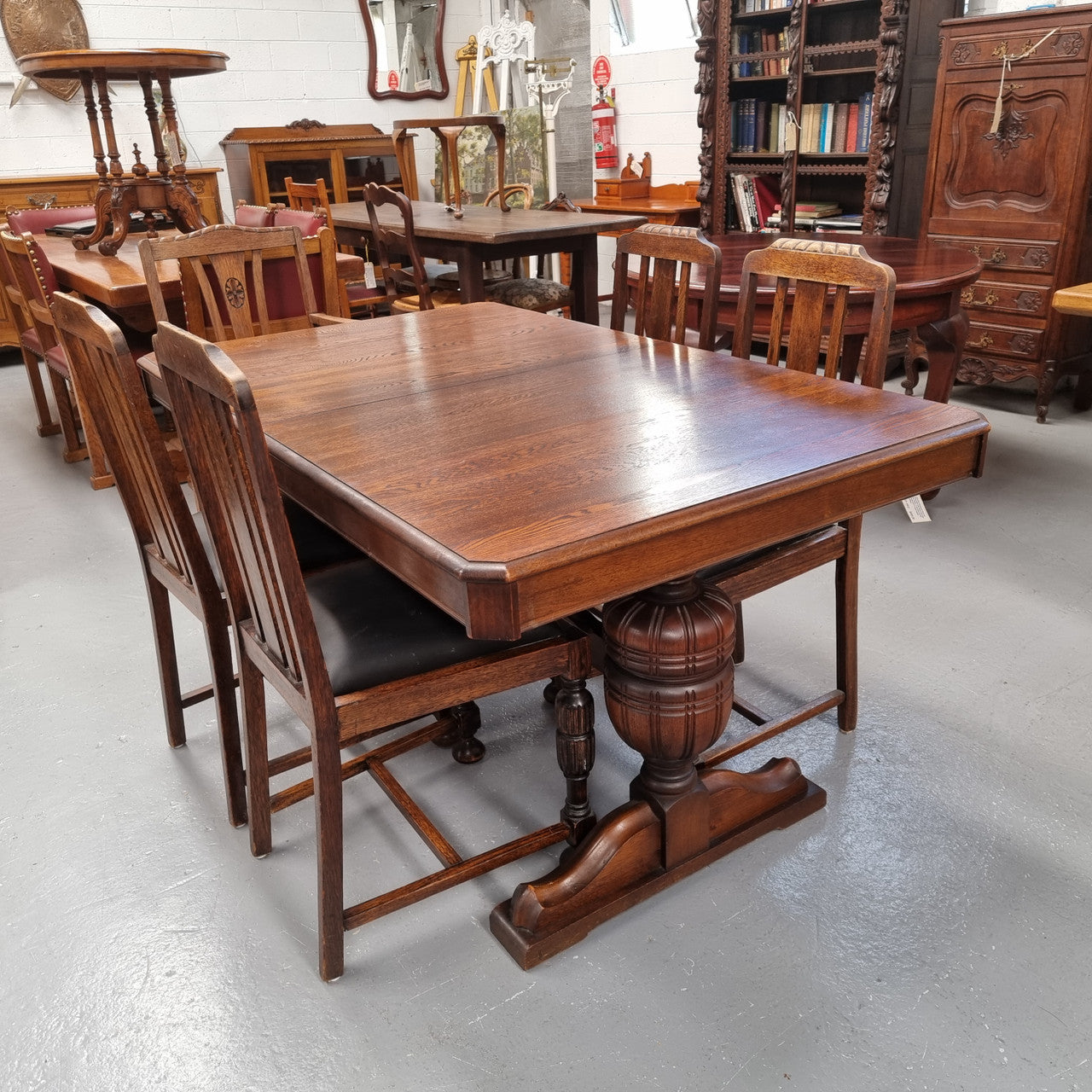 Tudor oak dining setting consisting of draw leaf extension table, 4 dining chairs and 2 carver chairs. Upholstery in excellent condition. Circa: 1930’s. The table, chair and carver chairs are in good original detailed condition.