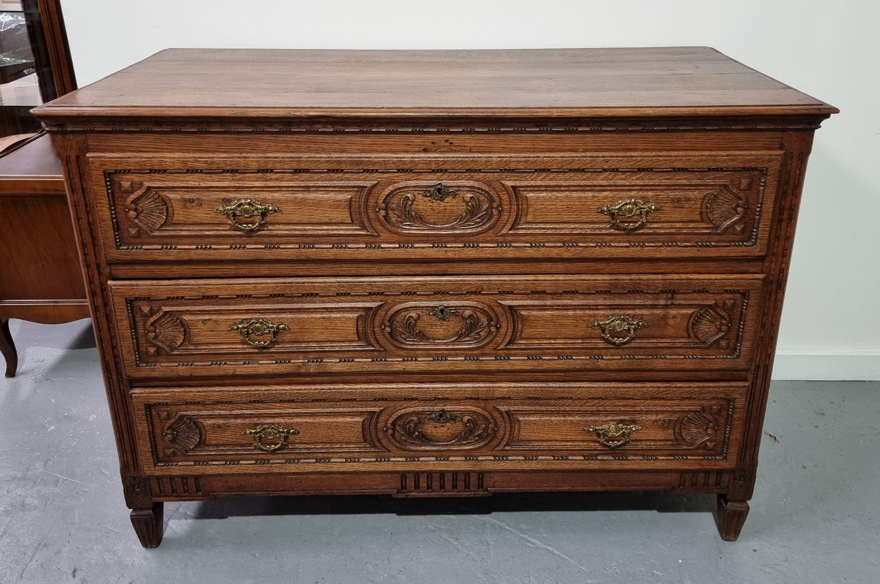 Early 19th Century French Oak chest of three drawers. It has beautiful handles and carvings. It is in good original detailed condition.