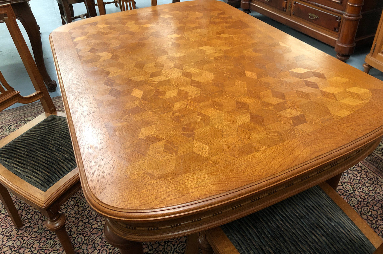 Lovely carved French Oak dining table with a parquetry top and six matching upholstered chairs in good original detailed condition.