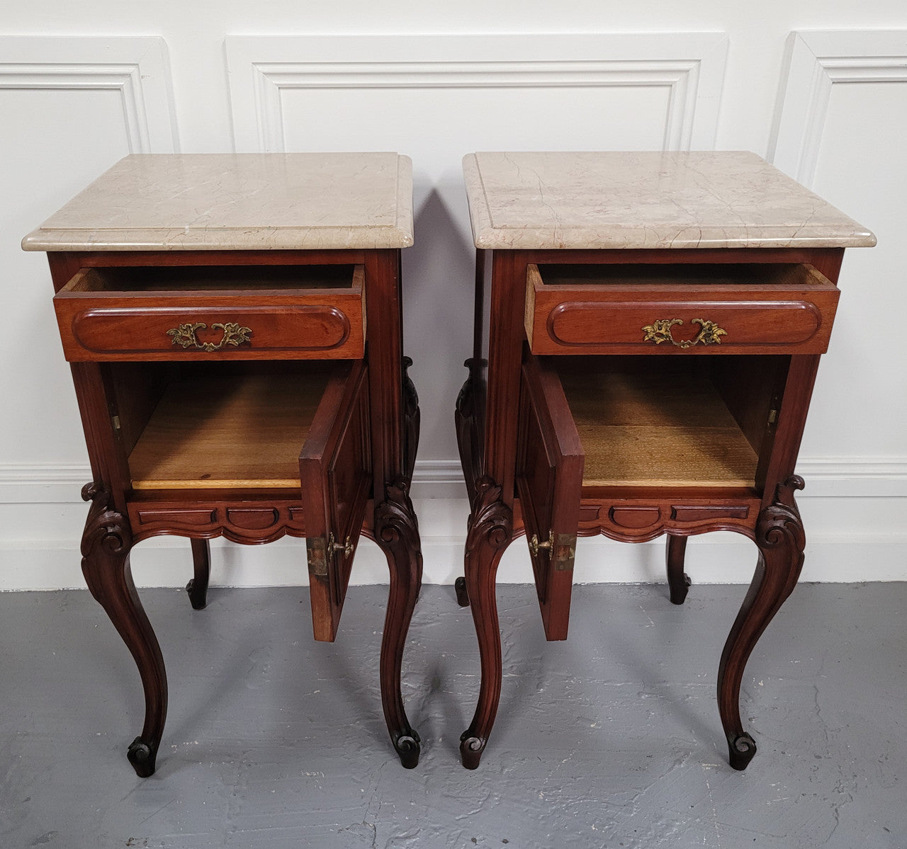 Pair of French Antiloopque Louis XV style Walnut and marble top bedsides. They have lovely carvings along with a drawer and cupboard space. They are in good original detailed condition and have been sourced from France