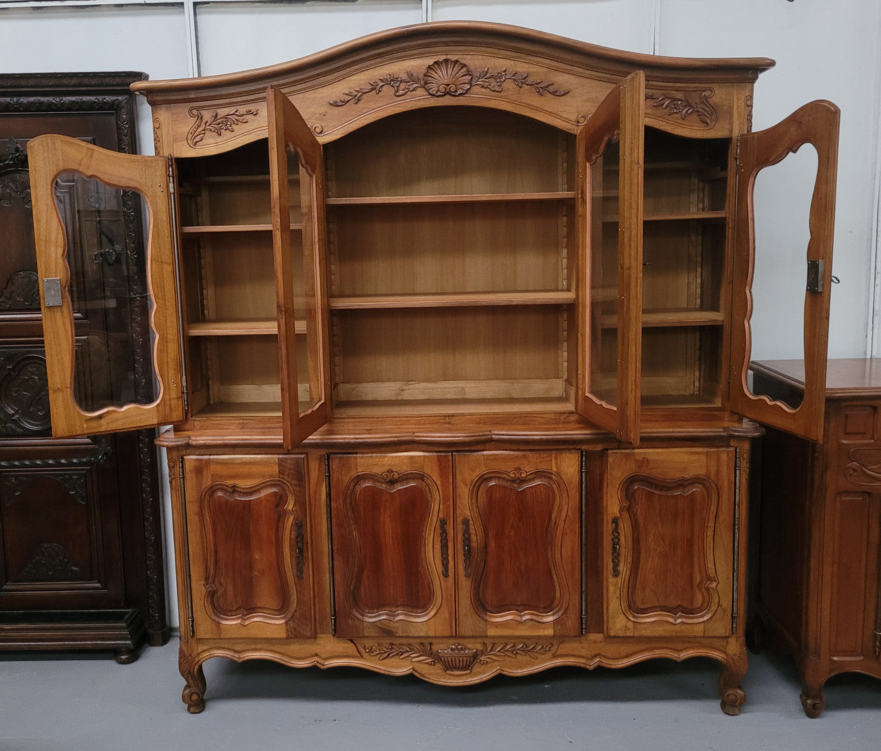Magnificent French Walnut two-body four door display cabinet. Heaps of storage space with four glass doors at the top with shelves and four solid doors below also with shelving. It has been sourced from France and comes with a key for each door and all are lockable. In good original detailed condition.