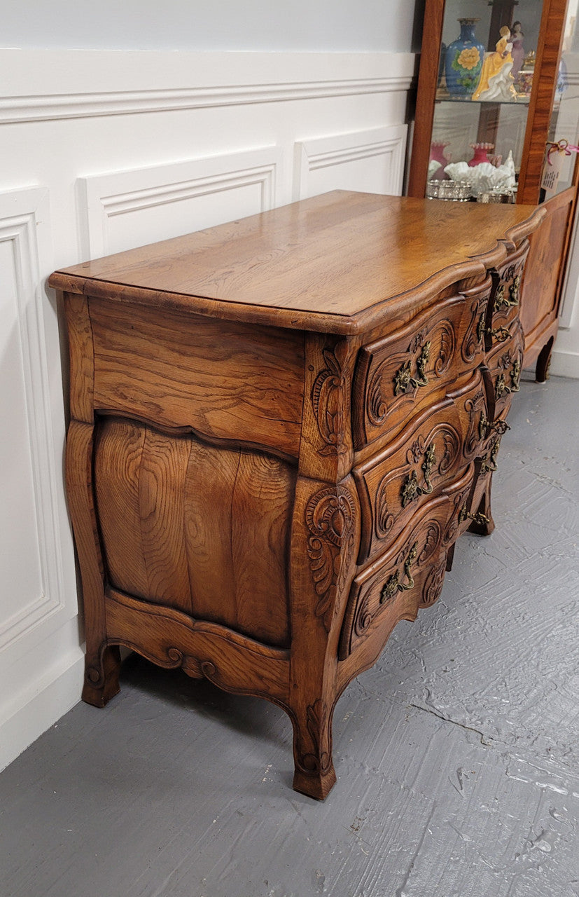 French Antique Louis XIV style Oak wooden top commode. It has a stunning serpentine bombe shape front along with amazing handles and carvings. It comes with three beautiful keys as pictured and comes with working locks. It has been sourced from France and in good original detailed condition.