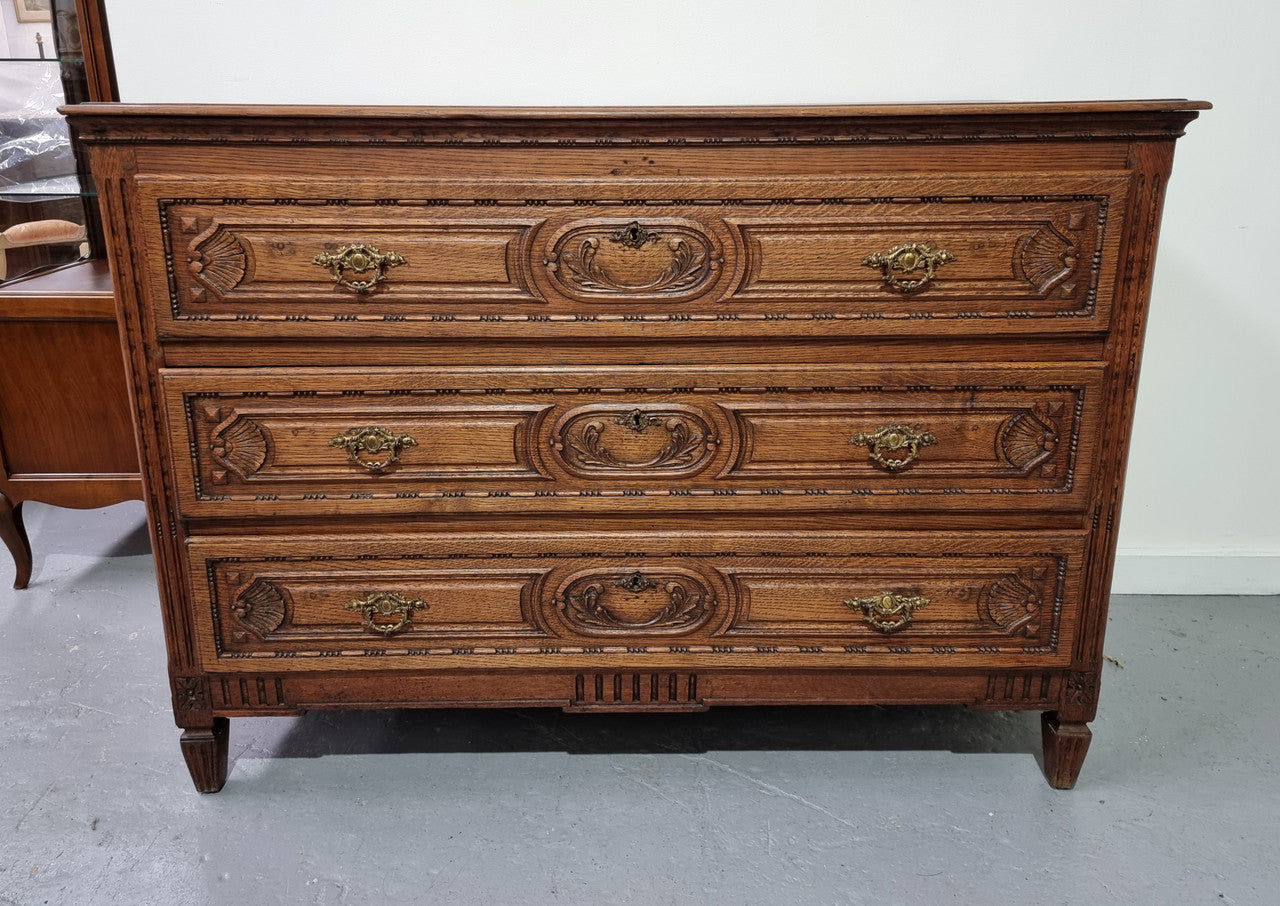 Early 19th Century French Oak chest of three drawers. It has beautiful handles and carvings. It is in good original detailed condition.