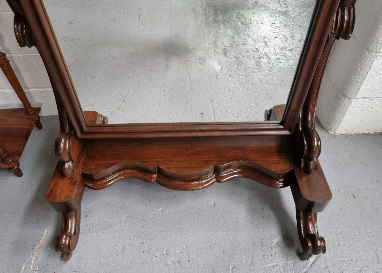 Antique Victorian 19th Century full length Mahogany cheval mirror. Mirror supported on two elegant scrolled upright support and stands on moulded base with four scrolled feet and castors.