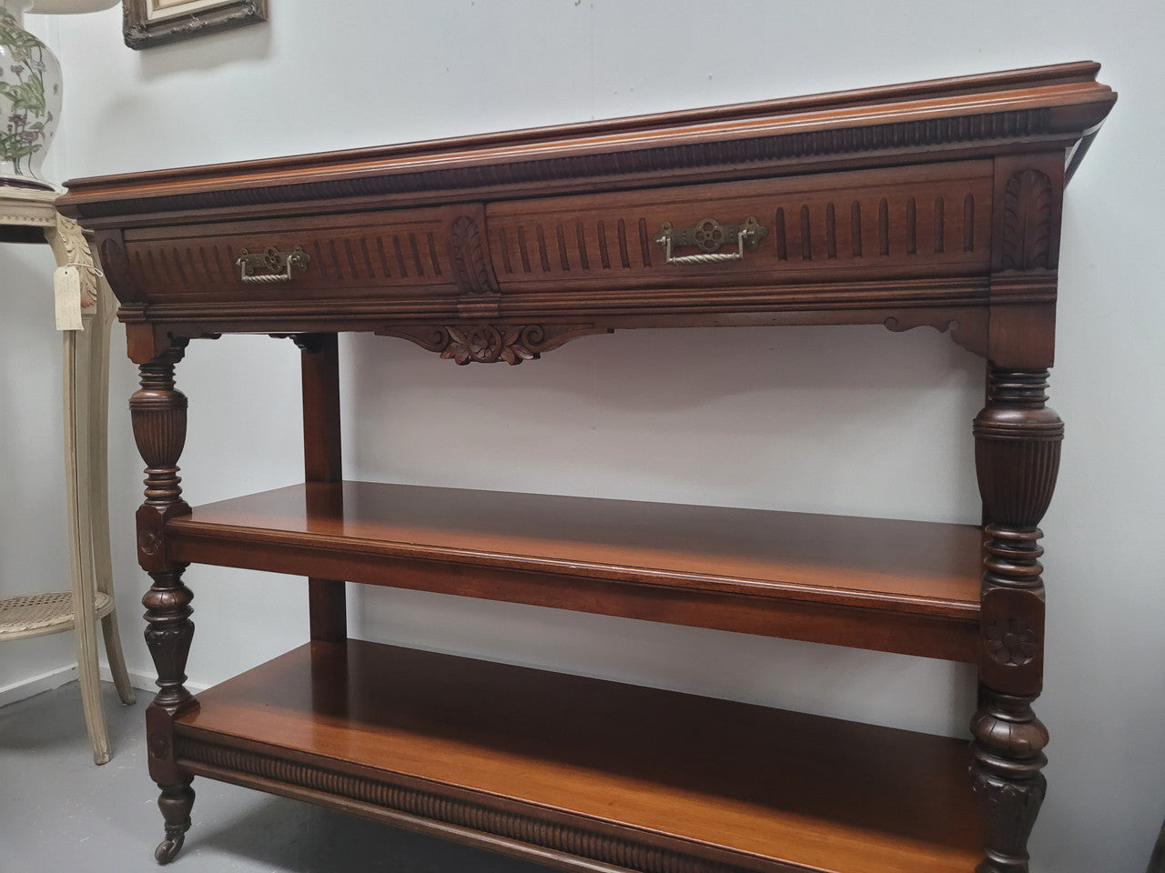 Fabulous quality Edwardian Walnut dumb waiter. It has two drawers and two shelves and is on casters. In good original detailed condition.