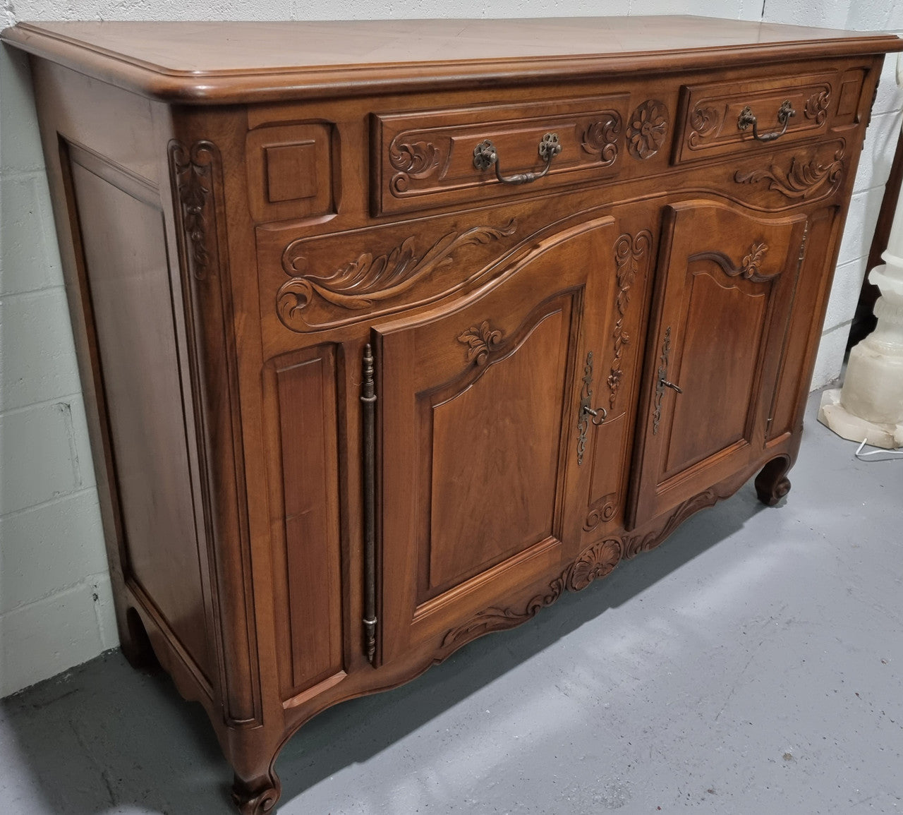 French Walnut two door buffet with parquetry top. It has two drawers and an adjustable shelf. In good original detailed condition and it has been sourced from France.
