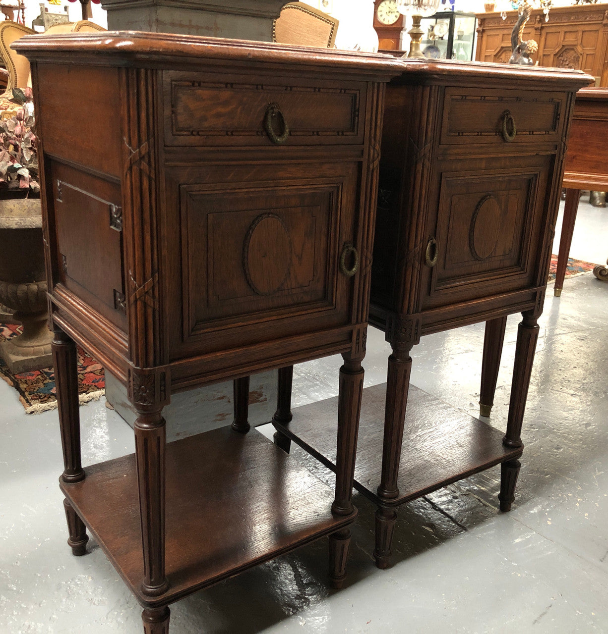 Lovely pair of French Oak Louis XVI style bedside cabinets with inset marble tops a drawer and a cupboard for storage. In good original detailed condition.