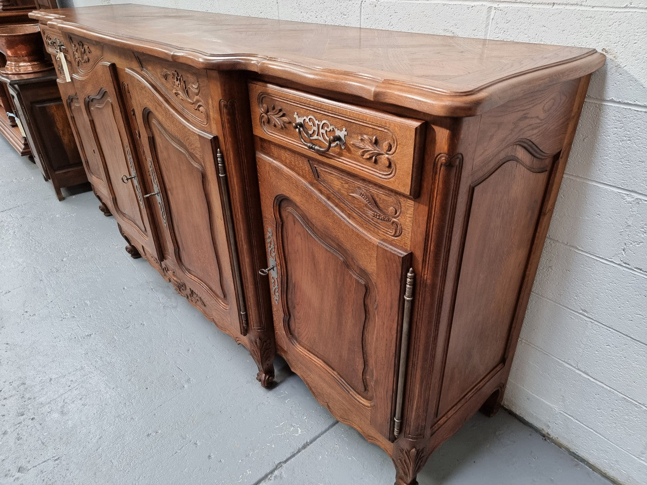Parquetry top French oak Louis XV style sideboard with two draws and four cupboards. In good original detailed condition.