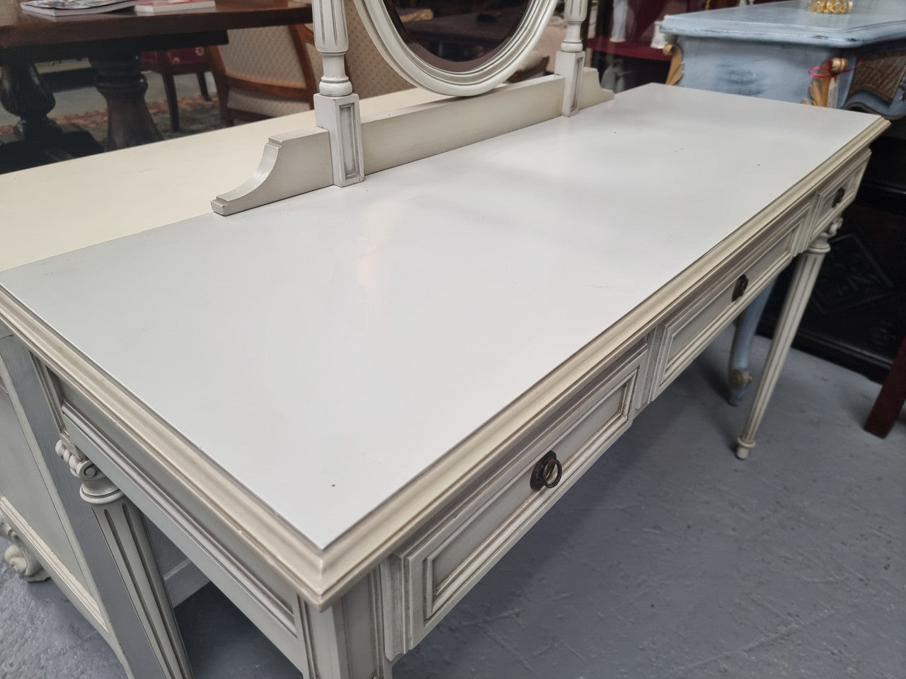 French Louis XVI style painted dresser / console with beveled oval mirror and three drawers. Sourced from France and in good original detailed condition.