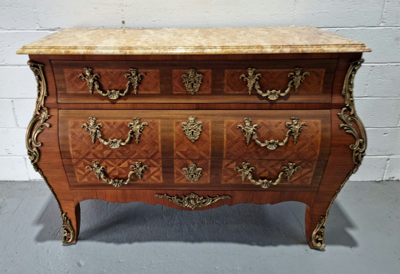A beautifully inlaid parquetry three drawer commode with a lovely marble top, and decorative ormolu mounts. In good original detailed condition. Circa 1930