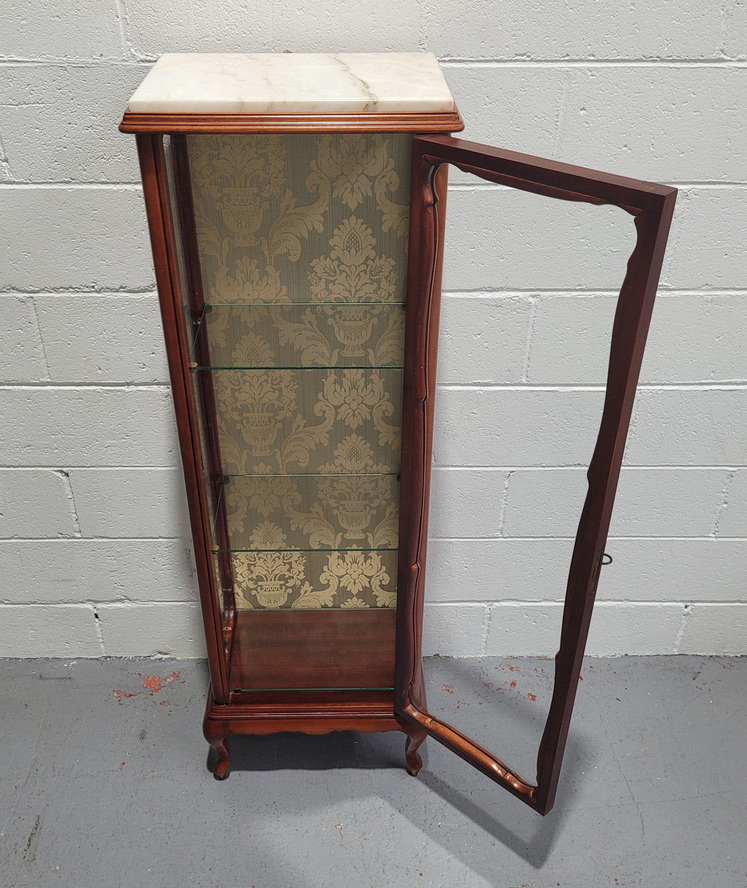 French Louis XV style small scaled display cabinet with marble top. It is of pleasing proportions with a lovely olive french damask fabric back and two glass shelves. In good original detailed condition.