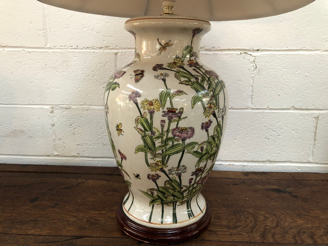 Contemporary ceramic lamp base decorated with daises & butterflies on a wooden base with shade.