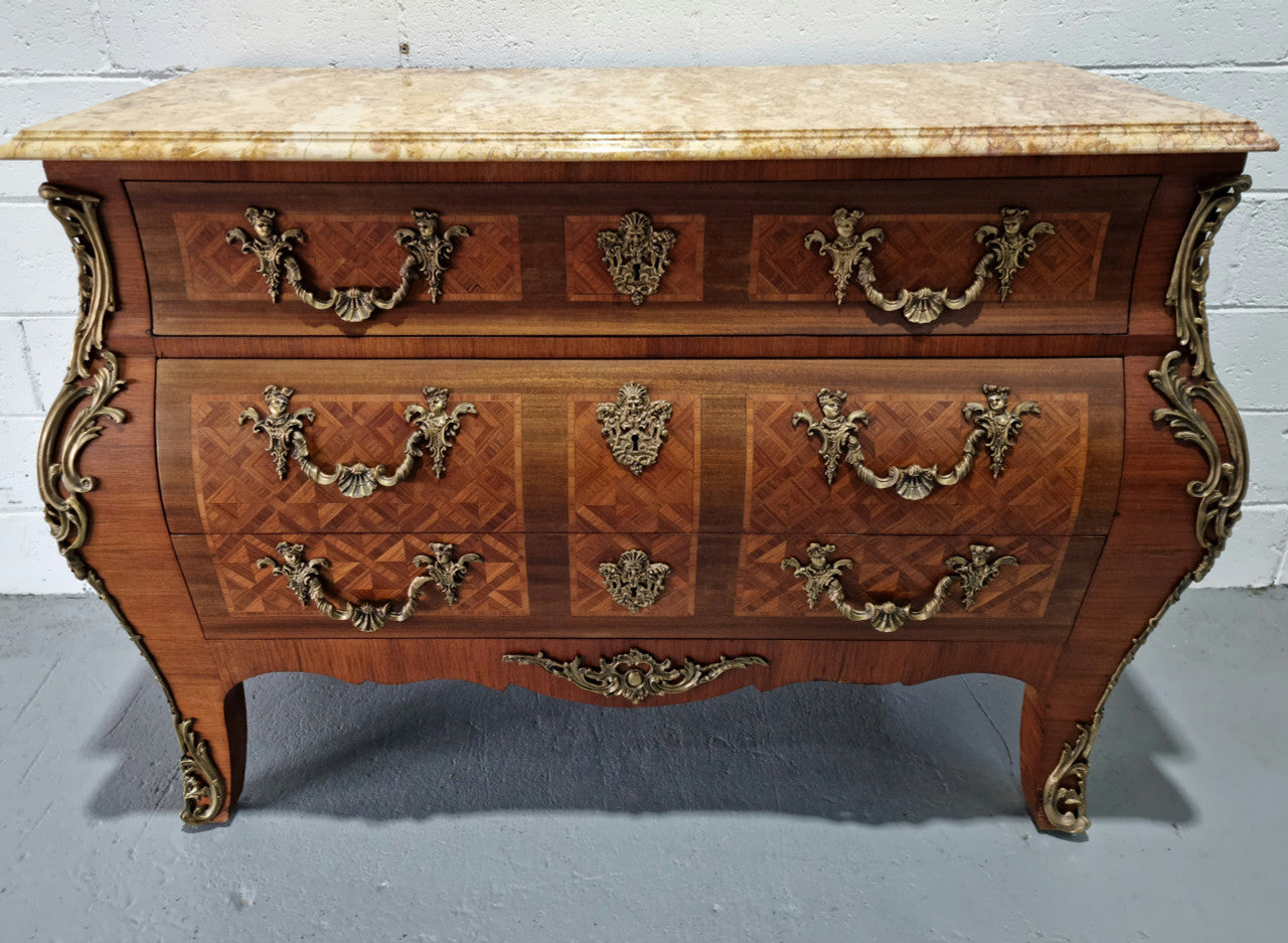 A beautifully inlaid parquetry three drawer commode with a lovely marble top, and decorative ormolu mounts. In good original detailed condition. Circa 1930