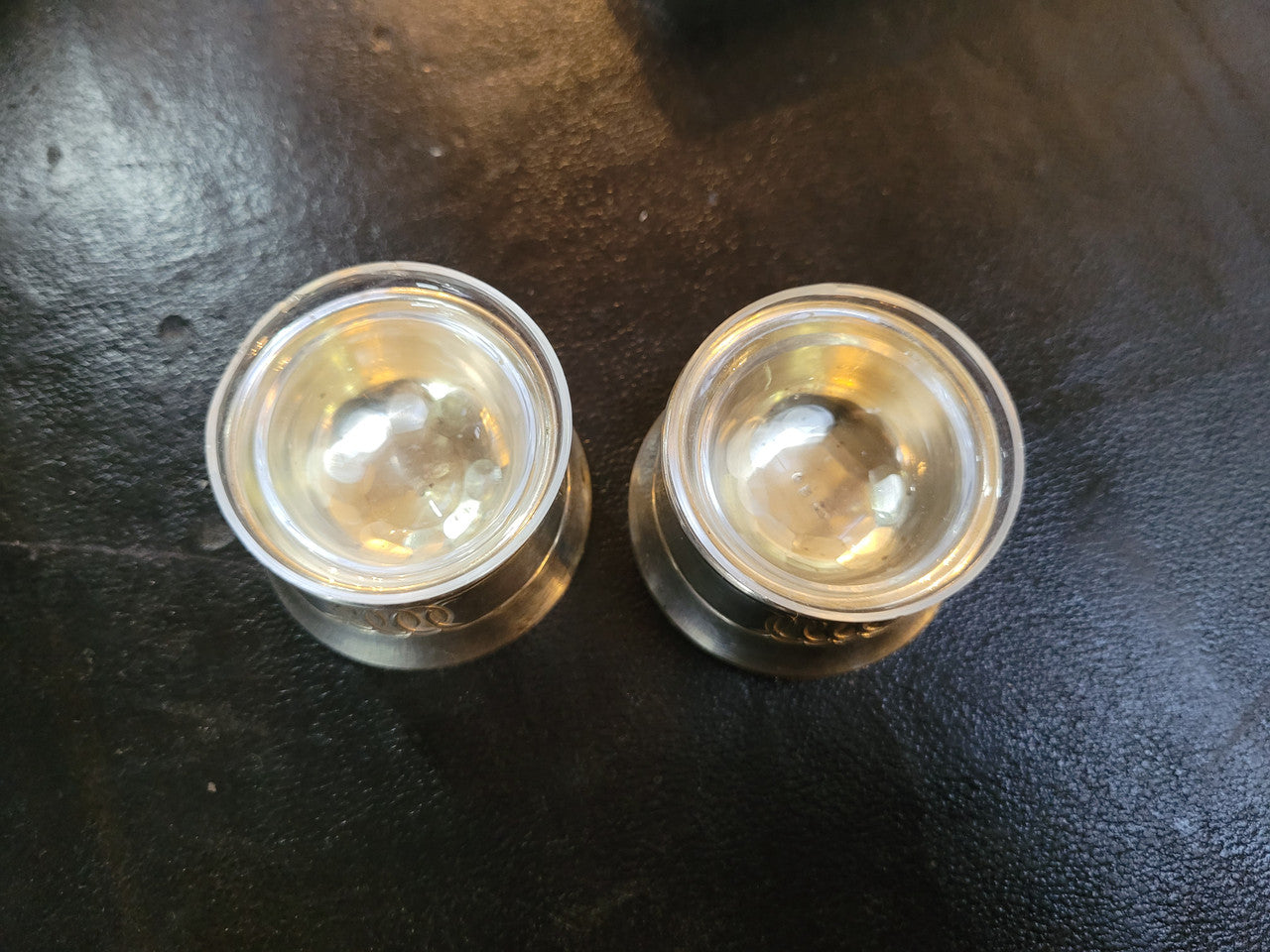 Pair antique silver salt cellars with liners. Stamped “800” 80g. 4.5cm Diam & 3cm Height. In good condition please view photos as they help form part of the description.