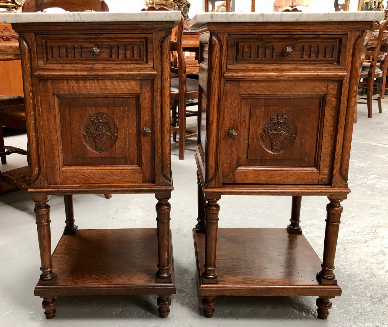A french oak pair of carved bedside cabinets, with lovely detail and nice coloured marble tops and plenty of storage space. In good condition.