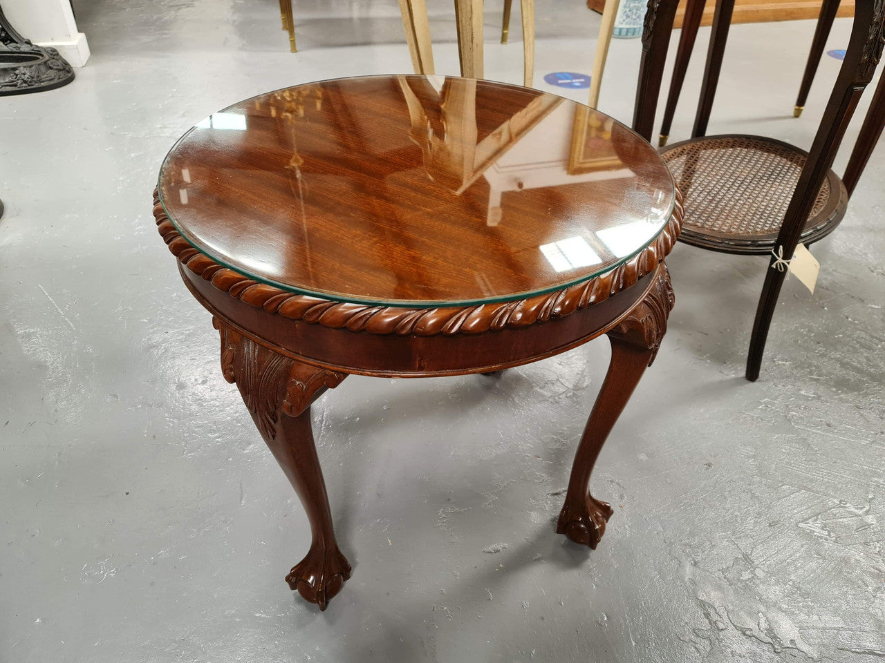 A beautiful round Mahogany Chippendale style coffee table with a glass top. In good original detailed condition.