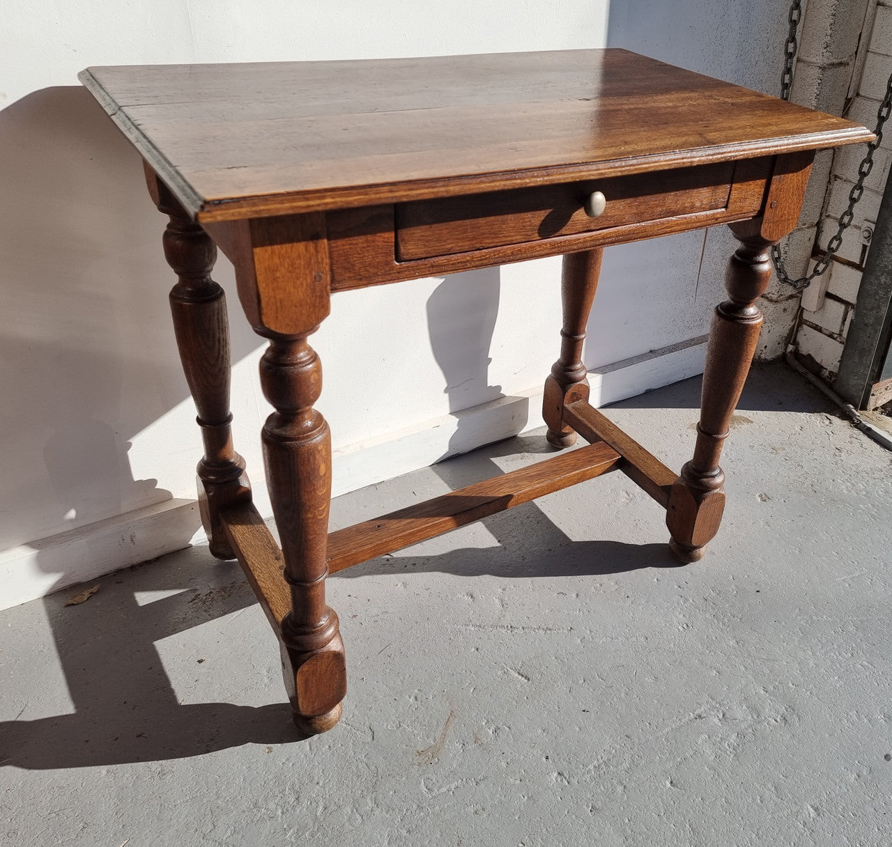 Rustic French Oak side table or desk with single drawer and turned legs. In good original detailed condition.