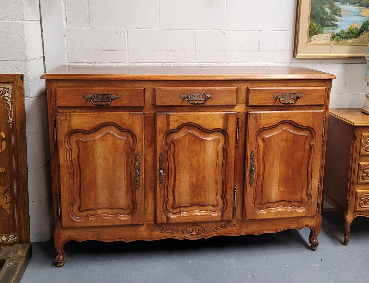 Beautiful French three door three drawer Louis XV style Cherrywood sideboard. It has a total of four adjustable shelves and comes with three keys. It has been sourced from France and is in good original detailed condition.