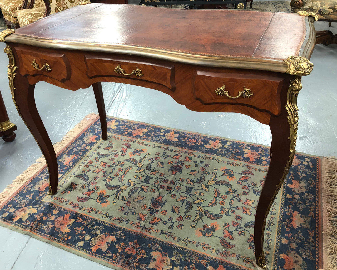 An impressive French Walnut petite Bureau Plat with superb ormolu mounts, original tooled leather top with loads of character and drawers for storage. It is in very good original detailed condition.