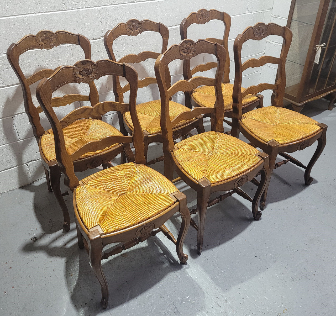 Set of six French Louis 15th style rush seated dining chairs. They are comfortable to sit in and are in original condition.