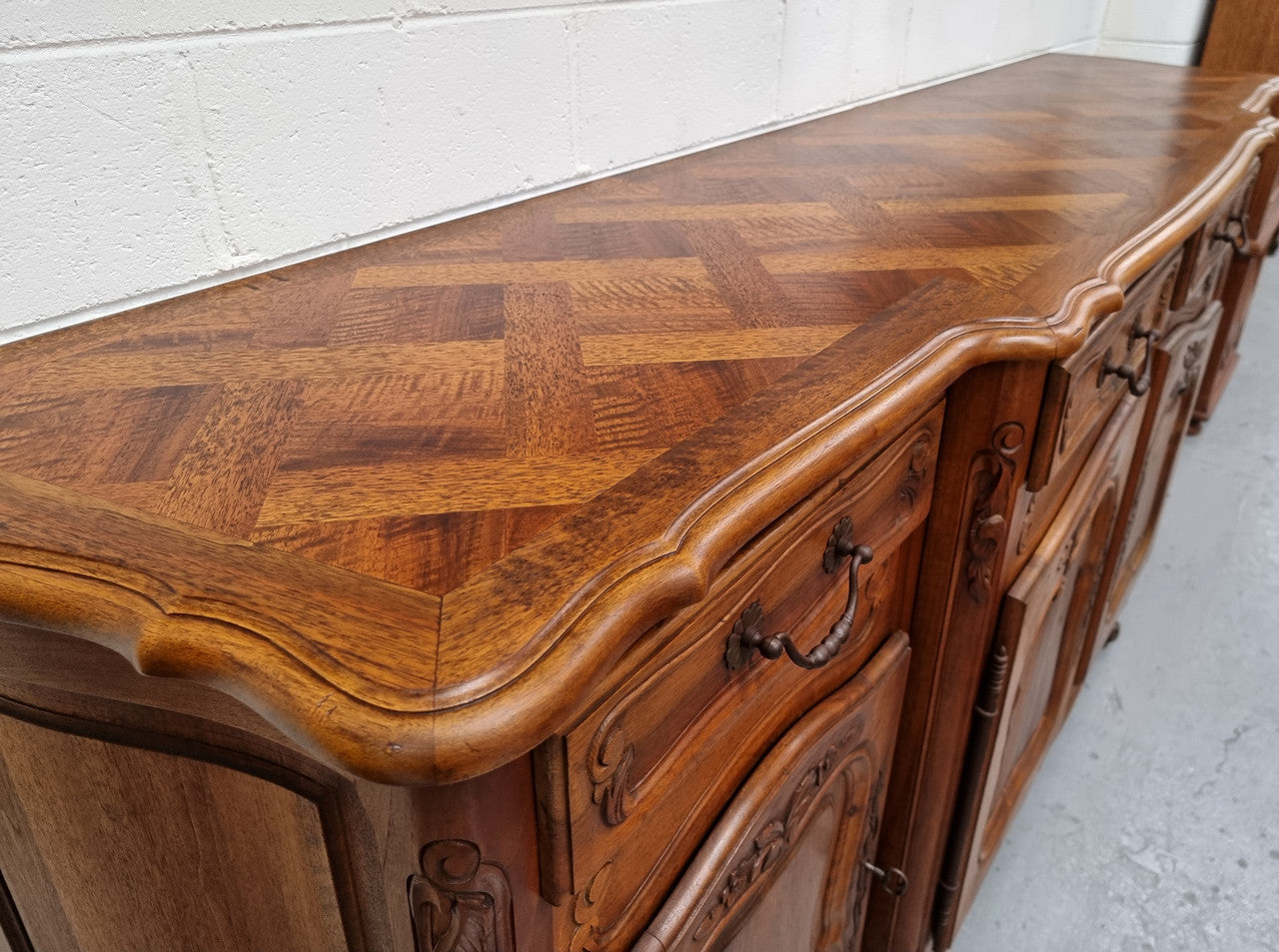 A Beautifuuly cavered French Walnut Louis XV style four door sideboard. Plently of storage space with four doors as well as four drawers. It is in good original detailed condition.
