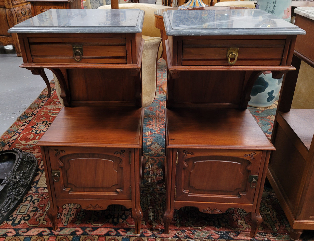Pair of unusual transitional fruit wood marble top bedside cabinets. They have been sourced from France and are in good original detailed condition.