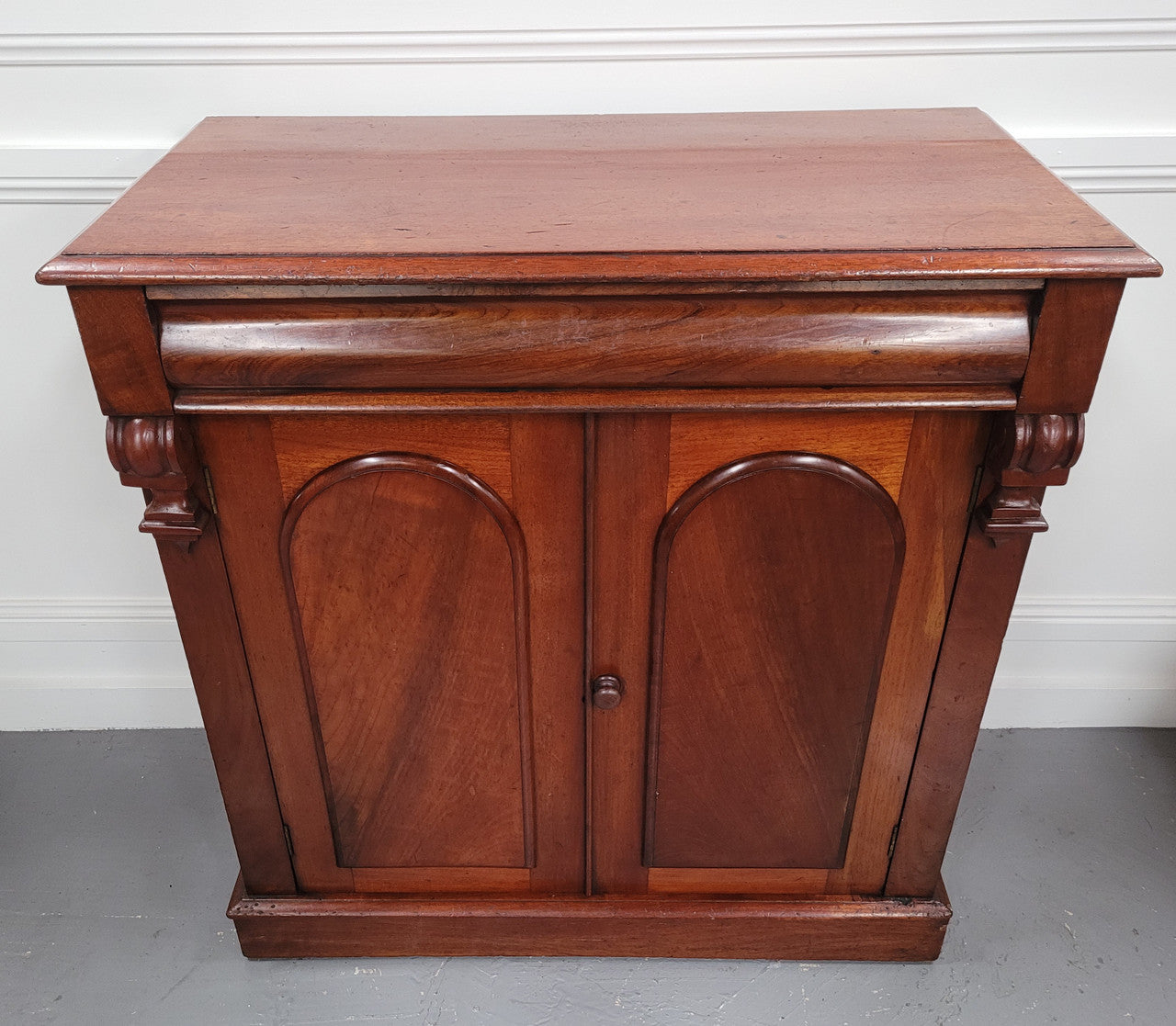 Cedar side cabinet with two doors one drawer and lovely door panels and corbels. It has been sourced locally and is in good original detailed condition.