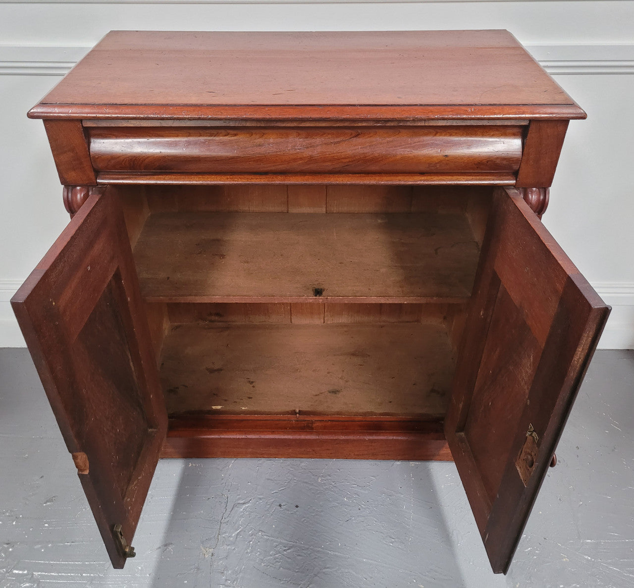 Cedar side cabinet with two doors one drawer and lovely door panels and corbels. It has been sourced locally and is in good original detailed condition.