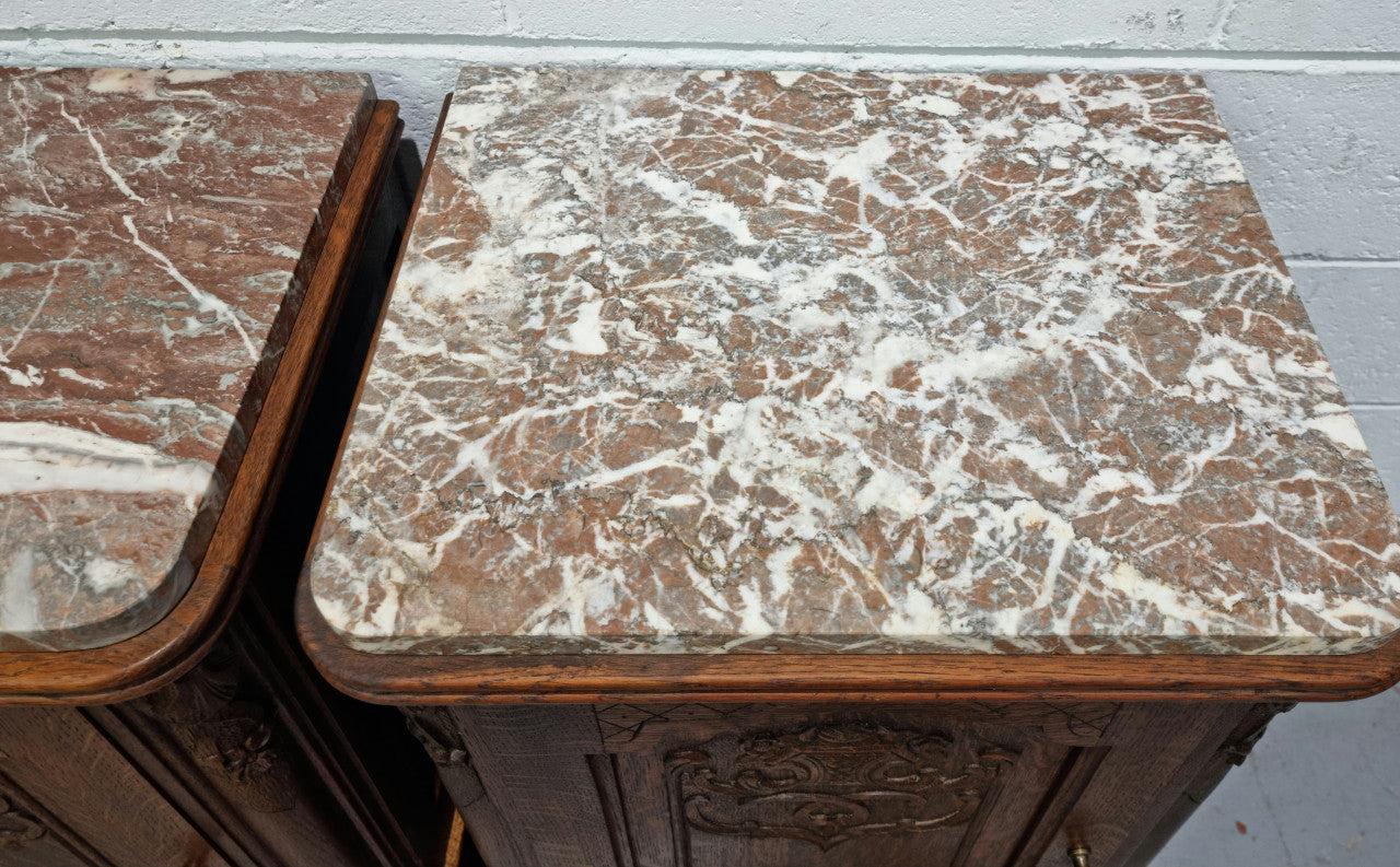 Lovely pair of French oak bedside cabinets with nicely carved details and marble tops. In good original detailed condition.