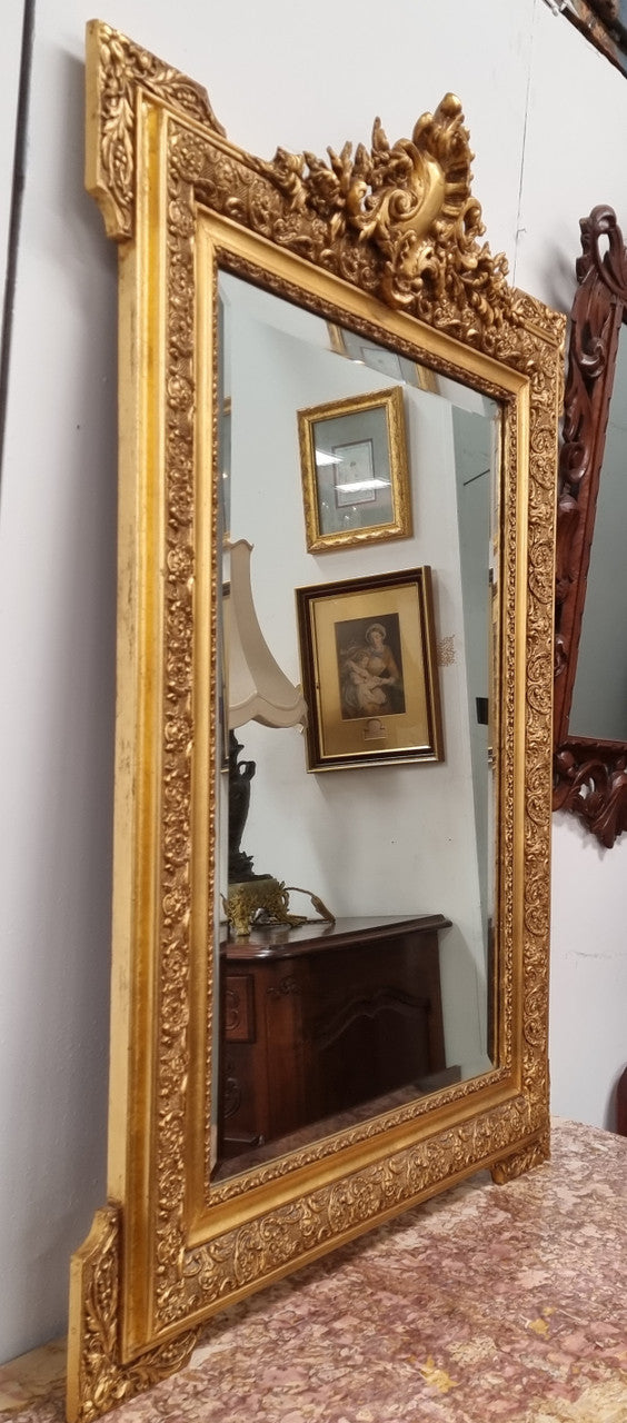 French ornate gilt decorated and floral bevelled mirror. It has been sourced from France and it is in good original condition.