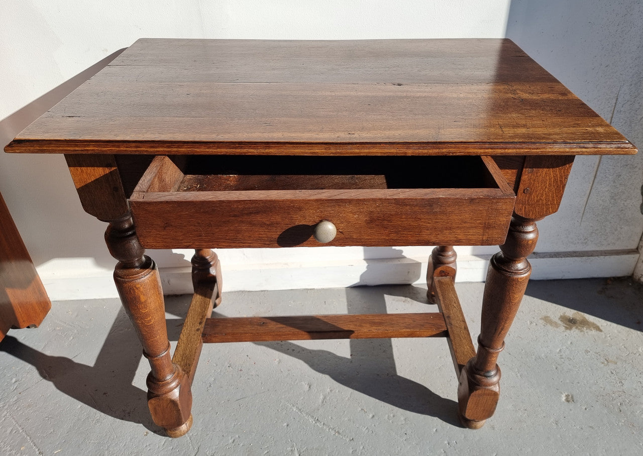 Rustic French Oak side table or desk with single drawer and turned legs. In good original detailed condition.