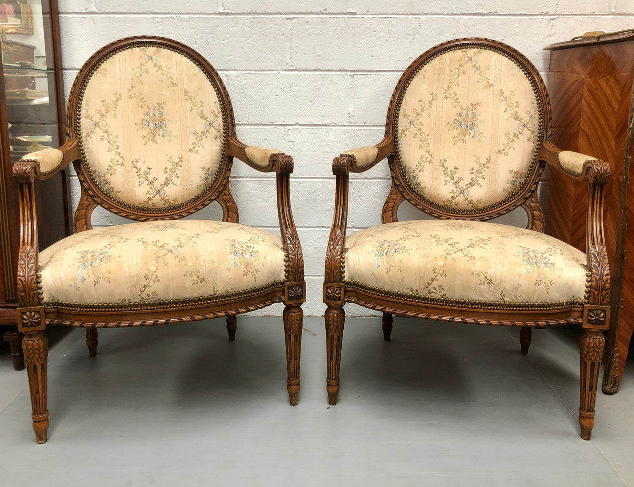 Pair of Antique French Louis XVI style carved Walnut fauteuils in restored condition. The Tapestry upholstery is in good condition some marks and wear but usable.