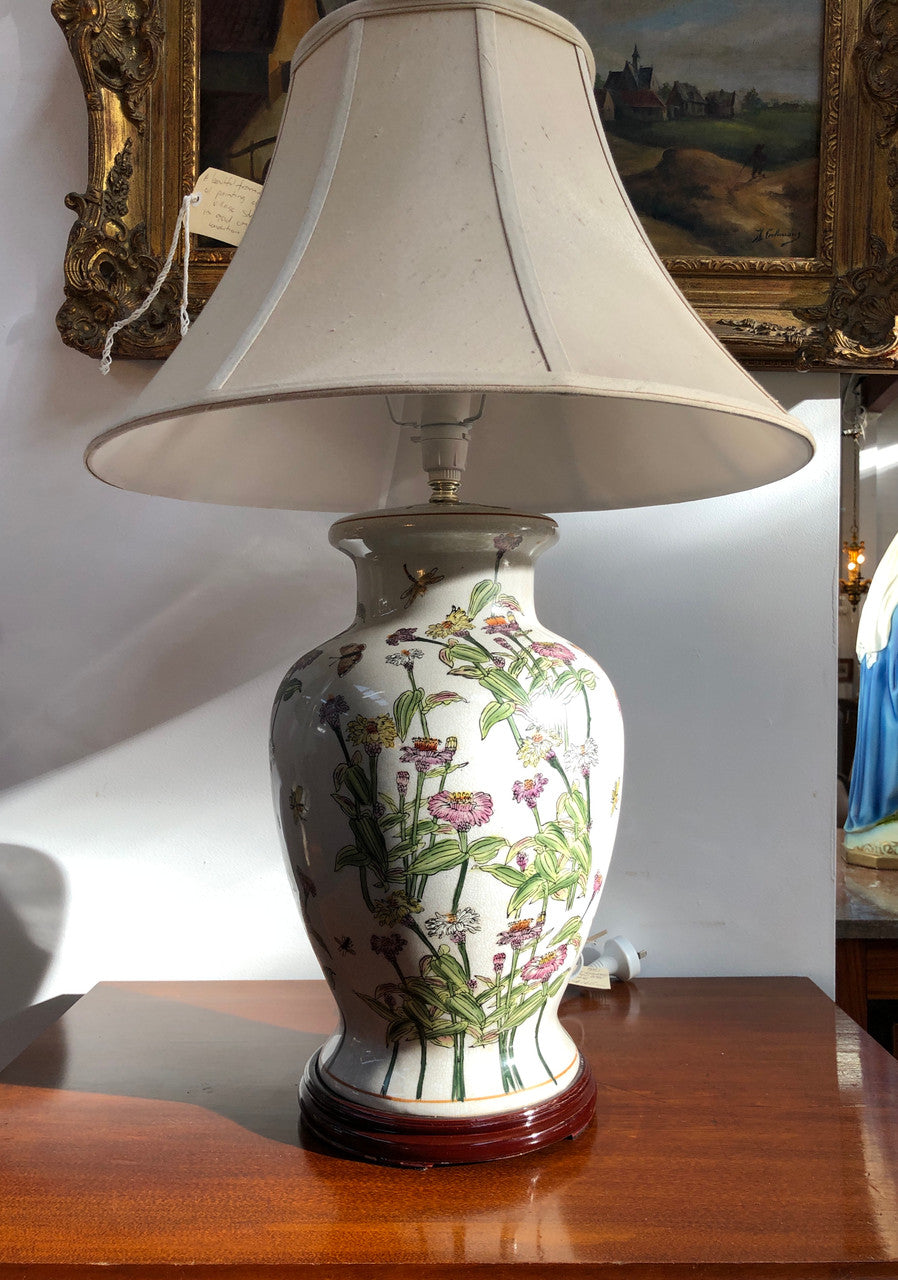 Contemporary ceramic lamp base decorated with daises & butterflies on a wooden base with shade.