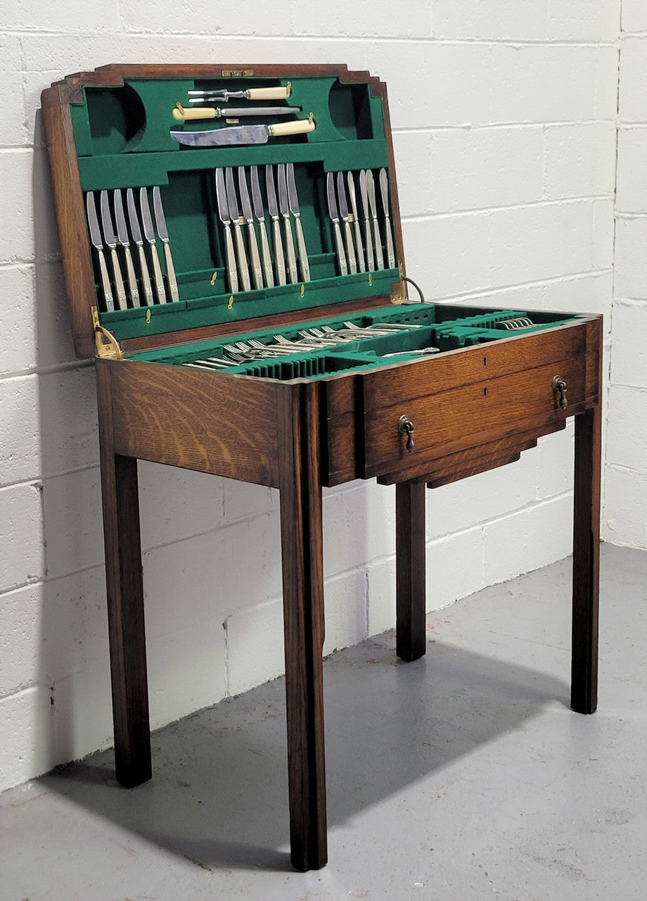 English Oak beautifully fitted cutlery table with a lift up top and drawer. Contains extensive silver plate part cutlery service by Elkington. In good original condition.