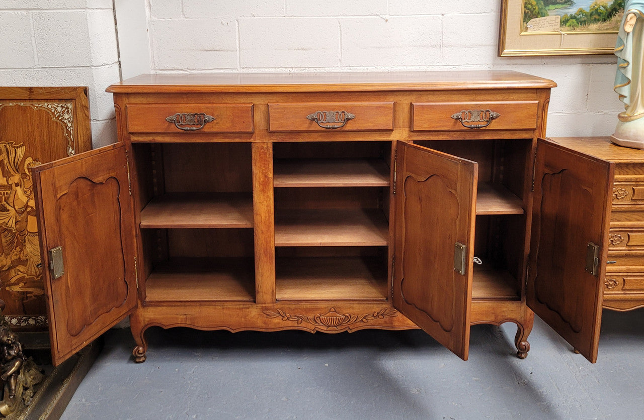 Beautiful French three door three drawer Louis XV style Cherrywood sideboard. It has a total of four adjustable shelves and comes with three keys. It has been sourced from France and is in good original detailed condition.