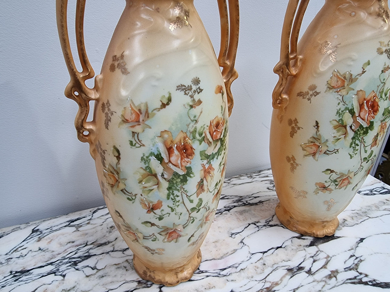 Decorative Pair of Art Nouveau Vases decorated with hand finished roses in muted tones. Gilt highlights. Impressed numbers to base. In good original condition, please view photos as they help form part of the description.