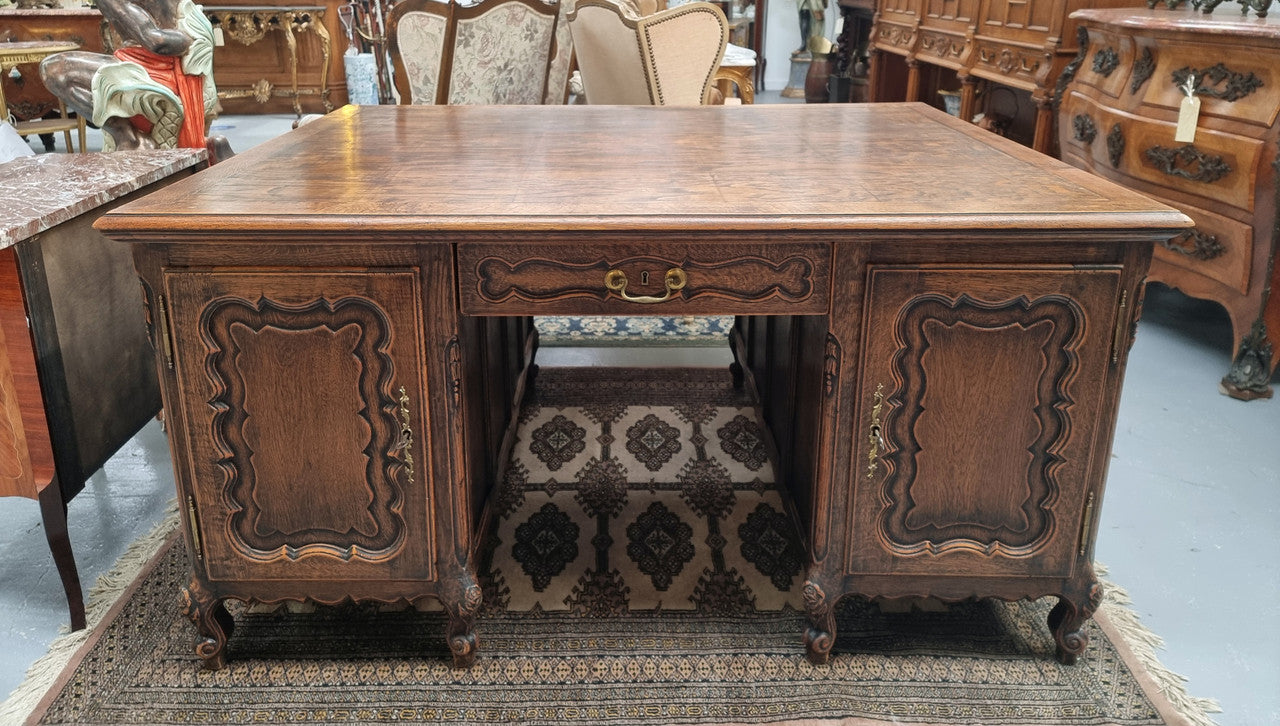 Fabulous Louis XV style French Oak beautifully carved full partners desk. Both sides have a functioning drawer in the middle and two cupboards either side. On both sides one cupboard door opens up to four smaller internal drawers. Plenty of storage space and a large top surface to work on. It is in good original detailed condition.