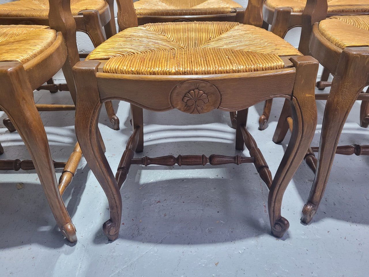 Set of six French Louis 15th style rush seated dining chairs. They are comfortable to sit in and are in original condition.
