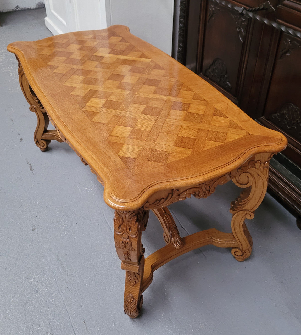 French Oak parquetry top coffee table with decorative carved base. It is in good original detailed condition.
